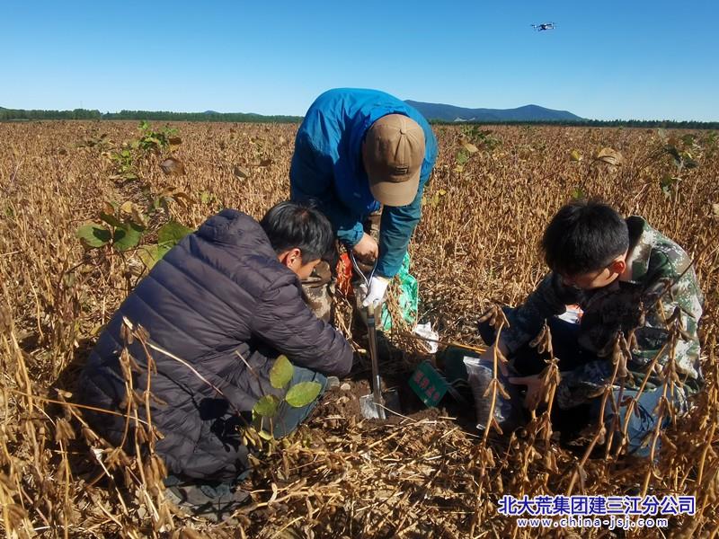图为生产部管理人员与取土样.jpg