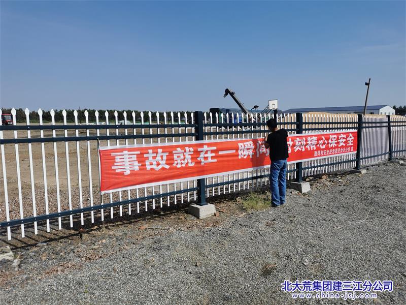 图为勤得利农场安全员悬挂安全条幅.jpg
